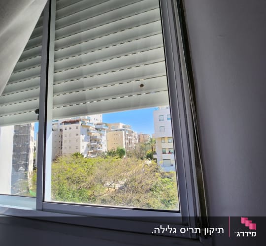 תריסים לבנים סגורים בחלון עם מסגרת מתכת